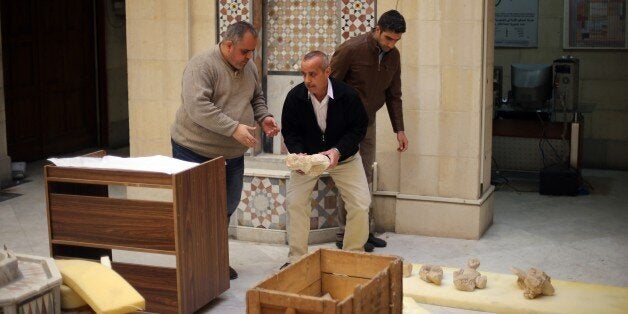 TO GO WITH AFP STORY BY SAMMY KETZDamascus Museum employees wrap archaeological artifacts into boxes to protect them from being damaged on March 24, 2015, in the Syrian capital. Workers at Syria's National Museum of Damascus carefully wrap statues and place them in boxes to be transported to a safe place, hoping to save the priceless pieces from theft or destruction. AFP PHOTO / JOSEPH EID (Photo credit should read JOSEPH EID/AFP/Getty Images)