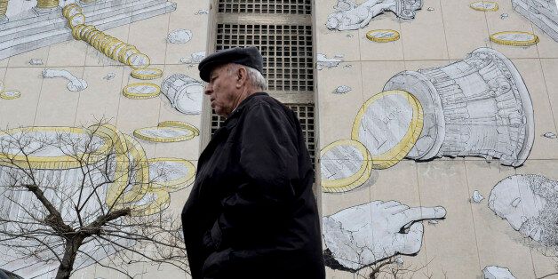 A man walks past a mural in the northern Greek town of Thessaloniki, on Wednesday, March 11, 2015. Greece is quickly running out of cash and has to repay debts this month to the International Monetary Fund â which co-funded Greece's 240 billion euro bailout â as well having as treasury bills coming due. (AP Photo/Giannis Papanikos)