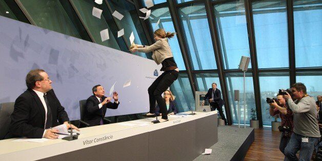 A woman interrupts a press conference by Mario Draghi, President of the European Central Bank, (ECB) following a meeting of the Governing Council ain Frankfurt / Main, Germany, on April 15, 2015. AFP PHOTO / DANIEL ROLAND (Photo credit should read DANIEL ROLAND/AFP/Getty Images)