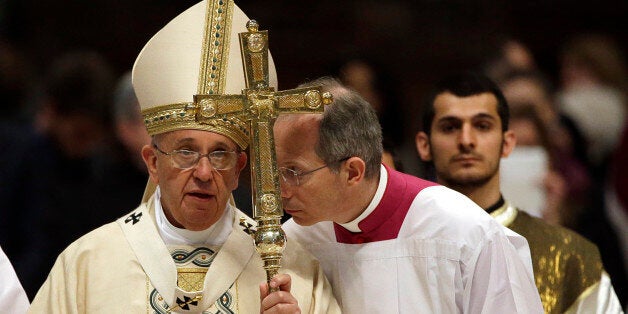 Monsignor Guido Marini, center, shares a word with Pope Francis, left, at the end of an Armenian-Rite Mass to commemorate the 100th anniversary of the Armenian Genocide, in St. Peter's Basilica, at the Vatican, Sunday, April 12, 2015. Pope Francis sparked a diplomatic incident with Turkey on Sunday by calling the slaughter of Armenians by Ottoman Turks âthe first genocide of the 20th century