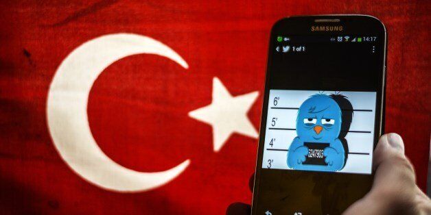 A picture representing a mugshot of the twitter bird is seen on a smart phone with a Turkish flag on March 26, 2014 in Istanbul. A Turkish court on Wednesday overturned the government's controversial Twitter ban imposed after audio recordings spread via the social media site implicated Prime Minister Recep Tayyip Erdogan in a corruption scandal. AFP PHOTO / OZAN KOSE (Photo credit should read OZAN KOSE/AFP/Getty Images)