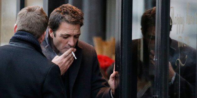 British businessman Ian Griffin, right, and an unidentified person smokes a cigarette during a break in a restaurant outside the Paris courthouse, Friday, Dec. 5, 2014. Griffin goes on trial for the 2009 murder of his girlfriend, who was found dead in the bathtub in the room they shared at a five-star Paris hotel. (AP Photo/Francois Mori)