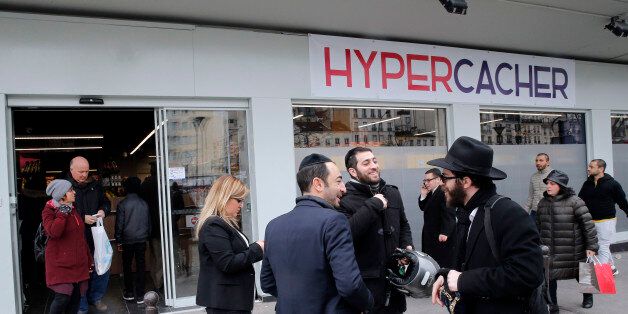 Customers chat in front of the Hyper Cacher during its reopening, in Paris, France, Sunday, March 15, 2015. The kosher supermarket was the scene of a deadly attack in January where Amedy Coulibaly killed four people. (AP Photo/Christophe Ena)