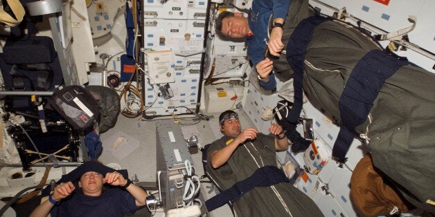 In this image provided by NASA, astronauts Pam Melroy, George Zamka, bottom right,and European Space Agency's Paolo Nespoli, sleep in their sleeping bags, which are secured on the middeck of the Space Shuttle Discovery while docked with the International Space Station, Thursday, Nov. 1, 2007. (AP Photo/NASA)