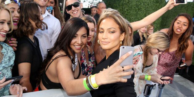 Jennifer Lopez takes a selfie with a fan as she arrives at the MTV Movie Awards at the Nokia Theatre on Sunday, April 12, 2015, in Los Angeles. (Photo by Matt Sayles/Invision/AP)