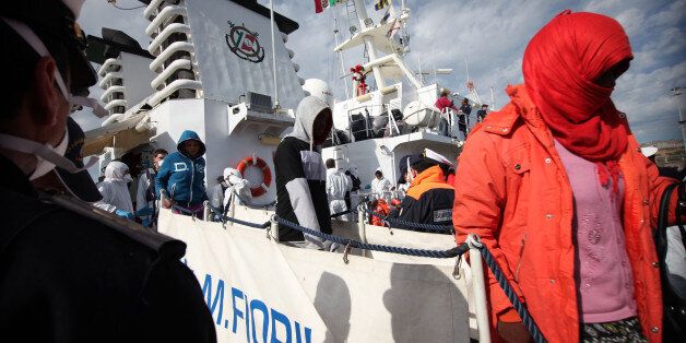 Migrants disembark from an Italian Coast Guard vessel after being rescued in Porto Empedocle, Sicily, southern Italy, Wednesday, March 4, 2015. In a dramatic sea rescue north of Libya, a flotilla of rescue ships saved nearly 1,000 migrants and refugees, while 10 migrants perished in the southern Mediterranean, Italian officials said Wednesday. The rescue vessels, including from Italy's coast guard and navy, and three cargo ships, saved 941 people in seven separate operations that began Tuesday,