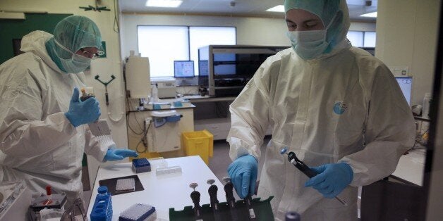 Forensic scientists of the Criminal Research Institute of the National Gendarmerie (IRCGN), collect DNA taken from the body parts of victims of the crash of a A320 Germanwings jetliner, in Pontoise, outside Paris, on March 30, 2015. The process of identifying the victims of Germanwings crash has now entered its active phase, but the families will still have to wait months to find out if their loved ones are among the bodies found. AFP PHOTO/POOL CHRISTOPHE ENA (Photo credit should read CH