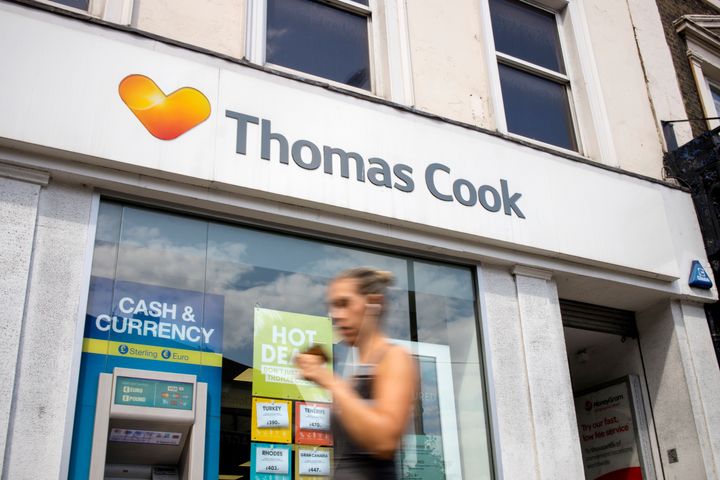 Pedestrians walk past a branch of a Thomas Cook travel agent's shop in London on July 12, 2019.