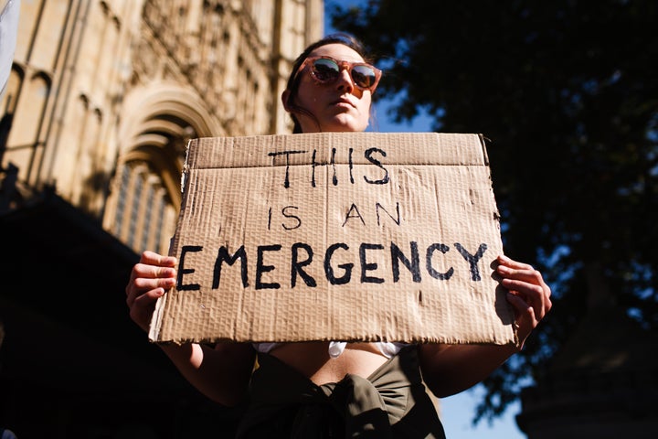 A protester holds a placard outside the Houses of Parliament in London during a climate demonstration.