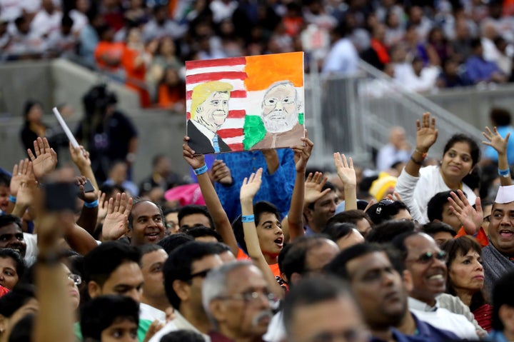 A boy holds a placard depicting President Donald Trump and India's Prime Minister Narendra Modi during the "Howdy Modi" event