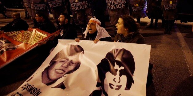 Kurds who live in Greece shouts slogans in front of riot police as they hold banners with the portraits of Turkish Berkin Elvan, left, and Greek Alexandros Grigoropoulos during a rally in Athens on Thursday, March 13, 2014. Hundreds of people tried to approach the Turkish Embassy in the Greek capital to protest against the death of the teenager in Istanbul but police blocked them outside the Greek Parliament. The 15-year-old boy, Berkin Elvan, died Tuesday, nine months after being hit by a polic