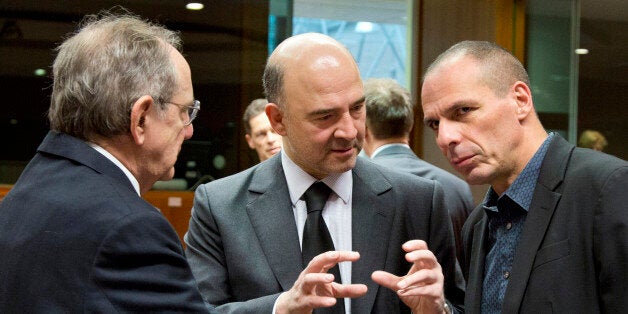 Greek Finance Minister Yanis Varoufakis, right, speaks with European Commissioner for the Economy Pierre Moscovici, center, and Italian Finance Minister Pier Carlo Padoan, left, during a meeting of EU finance ministers at the EU Council building in Brussels on Tuesday, March 10, 2015. Ministers on Tuesday will discuss the EU's banking union, the European semester and strategic investment. (AP Photo/Virginia Mayo)