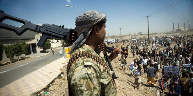 A Yemeni soldier stands guard as supporters of Ahmed Ali Abdullah Saleh, the son of Yemeni former President Ali Abdullah Saleh, gather during a demonstration demanding presidential elections be held and the younger Saleh run for the office, in Sanaa, Yemen, Tuesday, March 10, 2015. (AP Photo/Hani Mohammed)