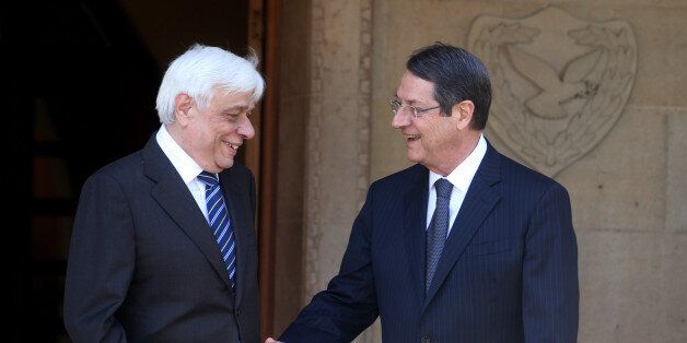 Cyprus' President Nicos Anastasiades, left, and President of Greece, Prokopis Pavlopoulos, prepare to shake hands at the presidential palace following a meeting in the capital Nicosia, Cyprus, Monday, March 30 , 2015. President of Greece Prokopis Pavlopoulos arrived in Cyprus for a two-day official visit, his first since assuming his duties.(AP Photos/Philippos Christou)