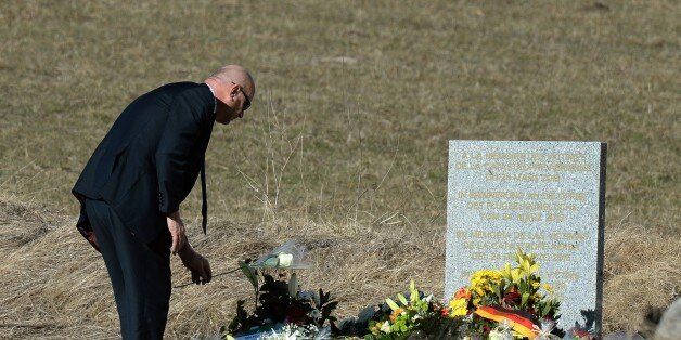 A man lays flowers at a memorial for the victims of the Germanwings plane crash in Le Vernet on March 27, 2015. The Germanwings co-pilot who crashed his Airbus into the French Alps, killing all 150 aboard, hid a serious illness from the airline, prosecutors said amid reports he was severely depressed. AFP PHOTO / BORIS HORVAT (Photo credit should read BORIS HORVAT/AFP/Getty Images)