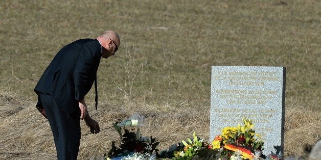 A man lays flowers at a memorial for the victims of the Germanwings plane crash in Le Vernet on March 27, 2015. The Germanwings co-pilot who crashed his Airbus into the French Alps, killing all 150 aboard, hid a serious illness from the airline, prosecutors said amid reports he was severely depressed. AFP PHOTO / BORIS HORVAT (Photo credit should read BORIS HORVAT/AFP/Getty Images)