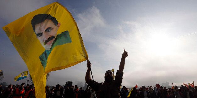 Kurds protest against the Islamic State militants attack on the Syrian city Kobani with a flag showing Kurdistan Workers' Party imprisoned leader Abdullah Ocalan in Duesseldorf, Germany, Saturday, Oct. 11, 2014. (AP Photo/Frank Augstein)