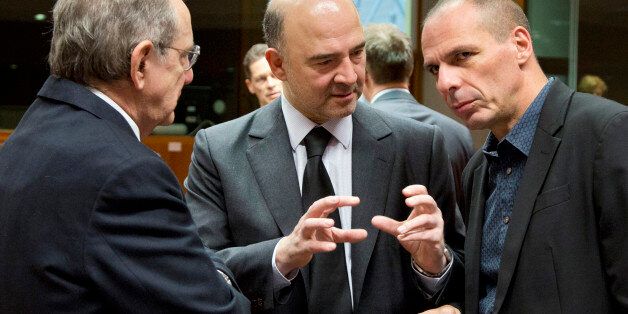 Greek Finance Minister Yanis Varoufakis, right, speaks with European Commissioner for the Economy Pierre Moscovici, center, and Italian Finance Minister Pier Carlo Padoan, left, during a meeting of EU finance ministers at the EU Council building in Brussels on Tuesday, March 10, 2015. Ministers on Tuesday will discuss the EU's banking union, the European semester and strategic investment. (AP Photo/Virginia Mayo)