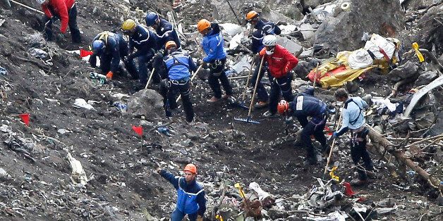 FILE - In this Thursday March 26, 2015 file photo, rescue workers inspect the debris from the Germanwings jet at the crash site near Seyne-les-Alpes, France. The somber mission to recover the remains of 150 people killed instantly when the Germanwings flight crashed full speed into the Col de Mariaud is not a quiet one and crucial physical evidence for the crash investigation can be gathered only when the mountains cooperate. (AP Photo/Laurent Cipriani, File)
