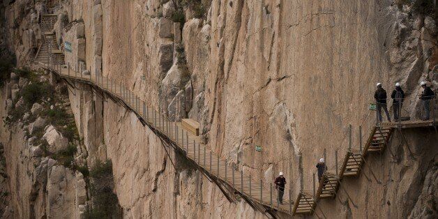 Journalists walk during a visit to the foot-path 'El Caminito del Rey' (King's little path) a narrow walkway hanging and carved on the steep walls of a defile in Ardales near Malaga on March 15, 2015. The one meter wide and 7.7 km long path, hanging from Ardales' defile at 100 meter high, was closed in the mid 90's after several hikers resulted dead when walking it. Once restored it will be reopened to the public on March 28, 2015. AFP PHOTO/ JORGE GUERRERO (Photo credit should read Jor
