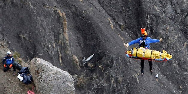 FILE - In this Thursday March 26, 2015 file photo a rescue worker is lifted into an helicopter at the crash site near near Seyne-les-Alpes, France. The somber mission to recover the remains of 150 people killed instantly when the Germanwings flight slammed full speed into the Col de Mariaud is not a quiet one and crucial physical evidence for the crash investigation can be gathered only when the mountains cooperate. (AP Photo/Laurent Cipriani, File)