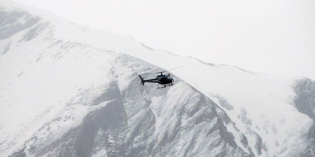 Rescue helicopters fly over the mountainside near Seyne-les-Alpes, French Alps, Tuesday, March 24, 2015. A Germanwings passenger jet carrying at least 150 people crashed Tuesday in a snowy, remote section of the French Alps, sounding like an avalanche as it scattered pulverized debris across the mountain. (AP Photo/Claude Paris)