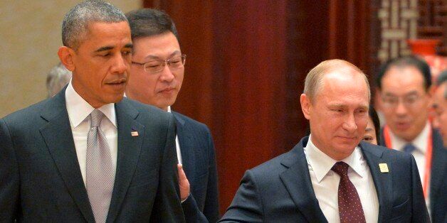 Russian President Vladimir Putin, right, passes by US President Barack Obama at the Asia-Pacific Economic Cooperation (APEC) Summit, Tuesday, Nov. 11, 2014 in Beijing. (AP Photo/RIA Novosti, Presidential Press Service)