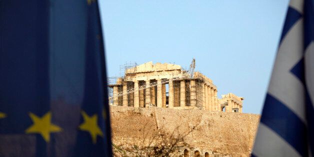 The Parthenon temple is seen between a European Union (EU) flag, left, and a Greek national flag on Acropolis hill in Athens, Greece, on Tuesday, Nov. 27, 2012. European finance ministers eased the terms on emergency aid for Greece, declaring after three years of false starts that Europe has found the formula for nursing the debt-stricken country back to health. Photographer: Kostas Tsironis/Bloomberg via Getty Images
