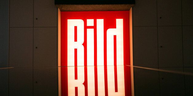 The logo of tabloid newspaper Bild, published by Axel Springer SE, sits illuminated in the company's offices in Berlin, Germany, on Wednesday, June 11, 2014. Axel Springer, Europe's biggest newspaper publisher, is working with JPMorgan Chase & Co. and Citigroup Inc. on an initial public offering of its digital-classifieds business, people familiar with the matter said. Photographer: Krisztian Bocsi/Bloomberg via Getty Images