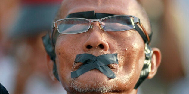 A protester displays how his rights were violated during an anti-coup demonstration at the Victory Monument in Bangkok, Thailand Wednesday, May 28, 2014. Thailand's new military junta aired videos Wednesday on television stations nationwide showing some of the prominent political figures it has detained as part of an effort to convince the public that detainees in army custody are being treated well. (AP Photo/Wason Wanichakorn)