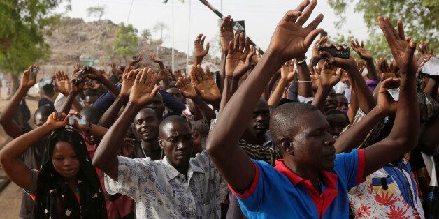 People displaced following attacks by Islamist militants raise their arms as they pass through security before casting their votes, in Yola, Nigeria, Saturday March 28, 2015. Nigerians went to the polls Saturday in presidential elections which analysts say will be the most tightly contested in the history of Africa's richest nation and its largest democracy. (AP Photo/Sunday Alamba)