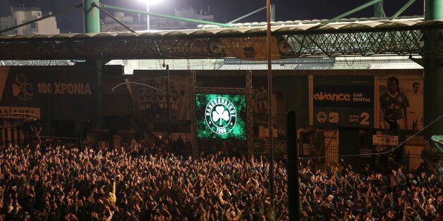 Panathinaikos' fans gather outside the Apostolos Nikolaides stadium to watch a Greek Super League soccer match between Panathinaikos and PAOK on a screen, in Athens, on Sunday, March 8, 2015. All the weekend soccer matches of the Greek Super League are to be played in front of empty stands, as talks between the Sports ministry of the new left-wing government and the country's soccer authorities aiming to combat the sports-related violence are still under way. (AP Photo/Yorgos Karahalis)
