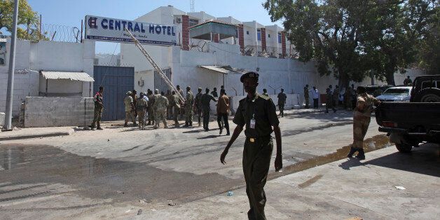 Somali security forces gather outside the scene of a twin bombing attack on a hotel in the capital Mogadishu, Somalia Friday, Feb. 20, 2015. One person rammed an explosives-laden vehicle into the gate of the Central Hotel in Somalia's capital, and another went through the gates and blew himself up, killing at least four people on Friday including the deputy mayor and a legislator, officials said, while the country's deputy prime minister was also among those wounded by the bombings. (AP Photo/Farah Abdi Warsameh)