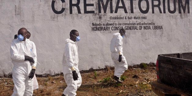 Health workers prepare to collect the ashes of people that died due to the Ebola virus at a crematorium on the outskirts of Monrovia, Liberia, Saturday, March 7, 2015. Traditional leaders from the fifteen counties in Liberia performed prayers at a crematorium that was used to burn the remains of people that passed away due to the Ebola virus. After the ceremony at the crematorium the remains were transported to a burial site were family members and traditional leaders gave their last blessin