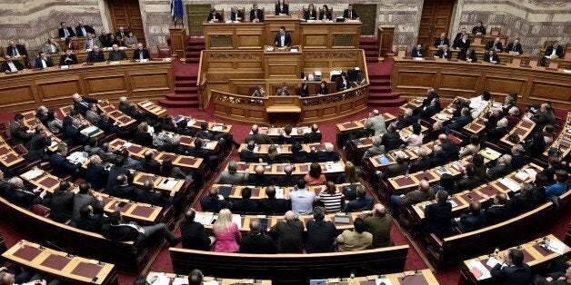 Greek Prime Minister Alexis Tsipras (C) addresses a parliament session in Athens on March 30, 2015. The EU warned Monday that Greece and its creditors had yet to hammer out a new list of reforms despite talks lasting all weekend aimed at staving off bankruptcy and a euro exit. AFP PHOTO / ARIS MESSINIS (Photo credit should read ARIS MESSINIS/AFP/Getty Images)