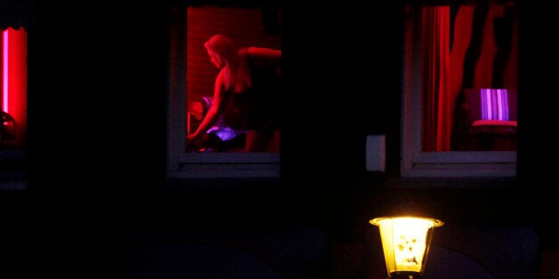 In this photo taken Monday Jan. 10, 2011 a prostitute advertises her wares behind red-lit windows in Amsterdam, Netherlands. Workers in the world's oldest profession are about to get a lesson in the harsh reality of Europe's new age of austerity. Amid budget cuts and falling revenues, the Dutch government has warned prostitutes who advertise their wares in the famed windows of Amsterdam's red light district to expect a business-only visit from the taxman this year. In a sign of the times, the move is meeting with little formal opposition, even among prostitutes, though some are skeptical it can be enforced. (AP Photo/Peter Dejong)