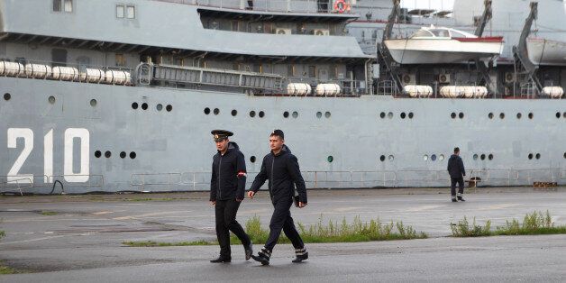 Russian sailors walk past the Russian navy boat Smolny before leaving the port of Saint-Nazaire western France, Thursday, Dec.18, 2014. Russian sailors are leaving the French Atlantic port without the controversial French-made warship they were supposed to sail away on. France suspended the delivery of the ship to Russia