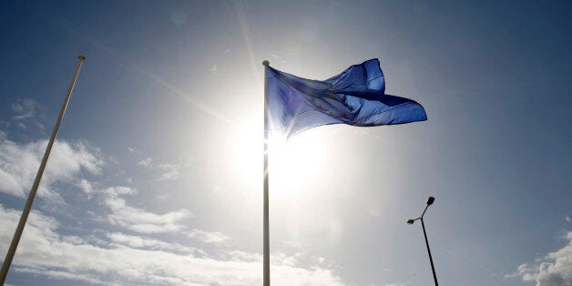 A European Union (EU) flag flies outside the Hellenic Stock Exchange in Athens, Greece, on Tuesday, Feb. 24, 2015. Greece moved closer to winning an extension of financial aid after the head of the group of euro-region finance ministers said creditors were favorable toward the government's package of new economic measures. Photographer: Kostas Tsironis/Bloomberg via Getty Images