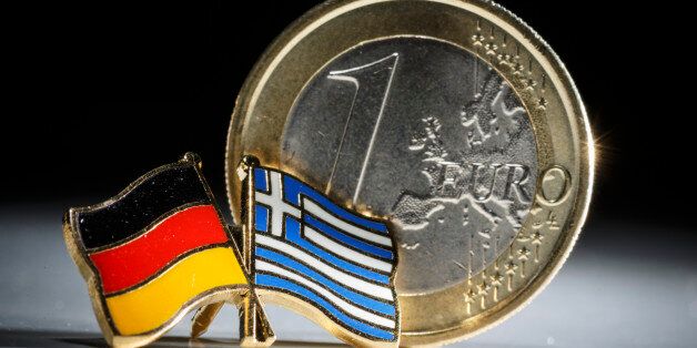 BERLIN, GERMANY - FEBRUARY 10: Symbolic photo of Greece and the Euro, one euro coin behind a badge with the national flags of Greece and Germany on February 10, 2015 in Berlin, Germany. (Photo by Thomas Trutschel/Photothek via Getty Images)