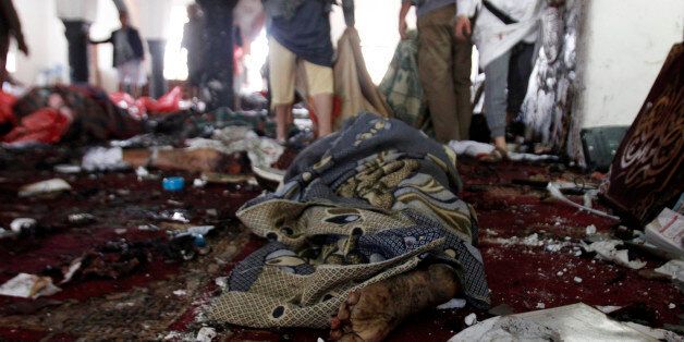 The victim of a suicide attack during the noon prayer is covered in a blanket in a mosque in Sanaa, Yemen, Friday, March 20, 2015. Triple suicide bombers hit a pair of mosques crowded with worshippers in the Yemeni capital, Sanaa, on Friday, causing heavy casualties, according to witnesses. The attackers targeted mosques frequented by Shiite rebels, who have controlled the capital since September. (AP Photo/Hani Mohammed)