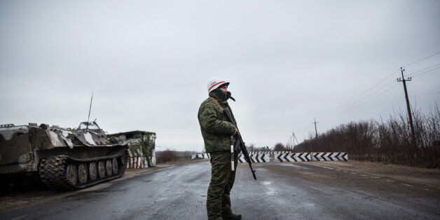 NOVOAZOVSK, UKRAINE - MARCH 04: A pro-Russian seperatist stands guard at a check point on the road heading to Mariupol on March 4, 2015 in Novoazovsk, Ukraine. Novoazovsk lies east of the port city of Mariupol, which many believe pro-Russian rebels may try to take control of next, in an effort to create a land bridge between the Russian annexed peninsula of Crimea and mainland Russia. (Photo by Andrew Burton/Getty Images)