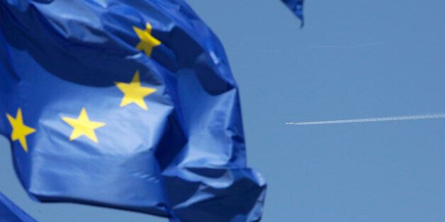 The flag of the European Union is caught in the wind as an unidentified aircraft flies over Brussels, Wednesday, May 25, 2011. A cloud of volcanic ash from Iceland that has caused headaches for air travelers spread to Germany on Wednesday, forcing the closure of Berlin's airports and disrupting hundreds of flights, but experts said the eruption appeared be winding down. European air traffic controllers said they expect about 700 flights to be canceled on Wednesday, but Eurocontrol in Brussels ad