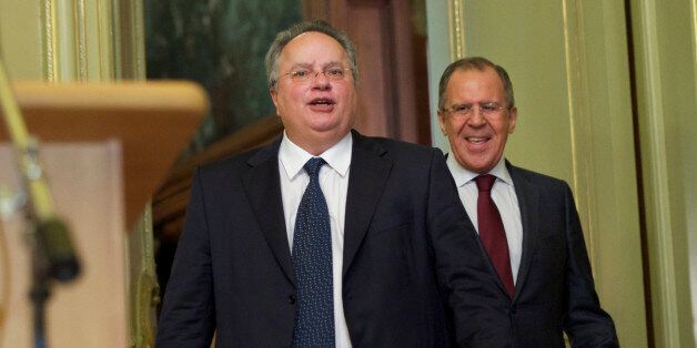 Greece's new Foreign Minister Nikos Kotzias, left, smiles as he arriving for a news conference after his talks with Russian Foreign Minister Sergey Lavrov, right, in Moscow, Russia, on Wednesday, Feb. 11, 2015. (AP Photo/Ivan Sekretarev)