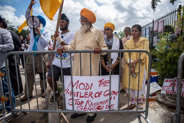 Protesters chant and wave flags outside after a rally attended by Indian Prime Minister Narendra Modi...