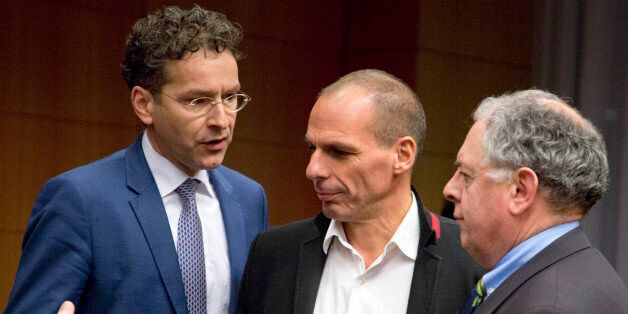 Greek Finance Minister Yanis Varoufakis, center, speaks with Dutch Finance Minister Jeroen Dijsselbloem, left, during a round table meeting of eurogroup finance ministers in Brussels on Friday, Feb. 20, 2015. Eurozone finance ministers meet for a crucial day of talks Friday to see whether a Greek debt relief proposal is acceptable to Germany and other nations using the common currency. (AP Photo/Virginia Mayo)