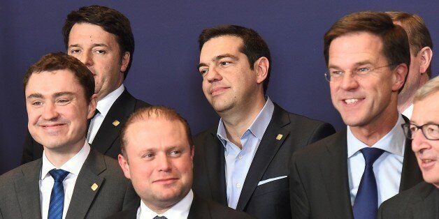 Greek Prime Minister Alexis Tsipras (C) pose with Italian Prime Minister Matteo Renzi (top L), Estonian Prime Minister Taavi Roivas (L), Maltese Prime Minister Joseph Muscat (C bottom), Dutch Prime Minister Mark Rutte (2R) and European Commission President Jean-Claude Juncker during a family photo at an European Council leaders summit in Brussels, February 12, 2015. AFP PHOTO / EMMANUEL DUNAND (Photo credit should read EMMANUEL DUNAND/AFP/Getty Images)