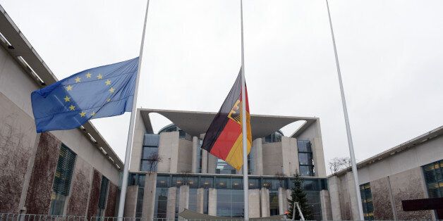 The European flag, left, and the German flag fly on half-staff in front of the Chancellery in Berlin, Germany, Thursday Jan. 8, 2015 to commemorate the victims killed in an attack at the Paris offices of the weekly newspaper Charlie Hebdo. Masked gunmen stormed the Paris offices of a weekly newspaper that caricatured the Prophet Muhammad, methodically killing 12 people Wednesday, including the editor, before escaping in a car. It was France's deadliest postwar terrorist attack. (AP Photo/d