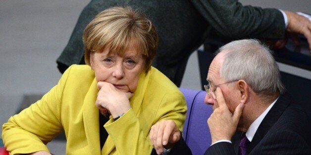 German Chancellor Angela Merkel (L) and German Finance Minister Wolfgang Schaeuble (R) chat during a session of the Lower house of parliament Bundestag on November 28, 2014 at the Reichstag building in Berlin before a vote to approve the budget blueprint for 2015. AFP PHOTO / JOHN MACDOUGALL (Photo credit should read JOHN MACDOUGALL/AFP/Getty Images)