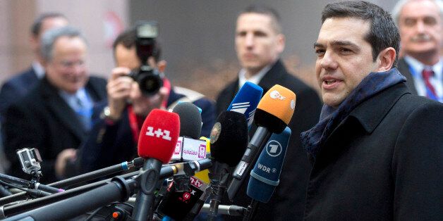 Greek Prime Minister Alexis Tsipras, second right, speaks with the media as he arrives for an EU summit in Brussels on Thursday, Feb. 12, 2015. European Union leaders on Thursday said the full respect of the planned weekend cease-fire in eastern Ukraine will be essential before there could be a change in the sanctions regime imposed on Moscow. (AP Photo/Virginia Mayo)