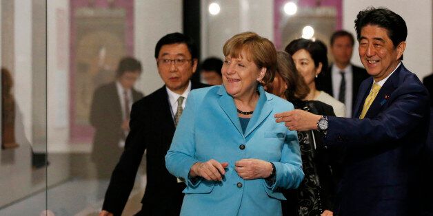 Shinzo Abe, Japan's prime minister, right, and Angela Merkel, Germany's Chancellor, react during a visit to the Nezu Museum in Tokyo, Japan, on Monday, March 9, 2015. Russia is violating Ukraine's territorial integrity and there is still hope for a diplomatic solution to the crisis, said Merkel. Photographer: Toru Hanai/Pool via Bloomberg